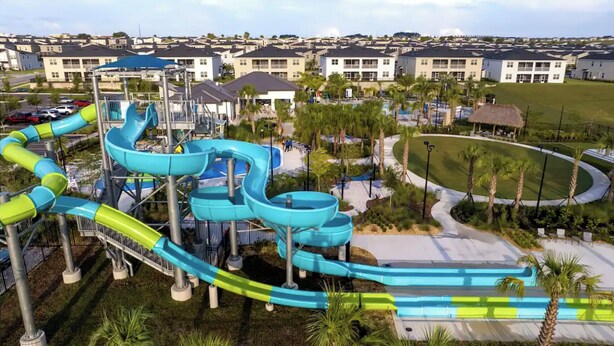 Parque acuático con toboganes múltiples y zona de piscina, rodeado de edificios residenciales.