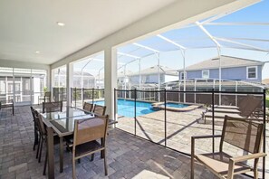 Relax by the pool with a clear view of the surrounding neighborhood from the glass-enclosed patio.