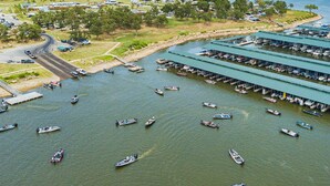 An aerial view of a marina with multiple docks and boats. - Large porch offers beautiful views of the lake. Enjoy unique interior design! (Mannford)