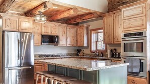 A kitchen with wooden cabinets, stainless steel appliances, and a granite countertop. - Tranquil cabin on Warm River, Ashton
Boat ramp access-fly fishing haven.  (Ashton)
