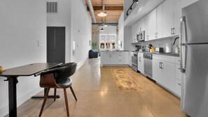 A modern kitchen with white cabinets, stainless steel appliances, and a wooden ceiling. - Spacious Sanctuary | Near DT Action (Greenville)