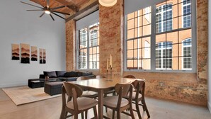 Une pièce spacieuse avec une grande table à manger, un canapé et un ventilateur de plafond.