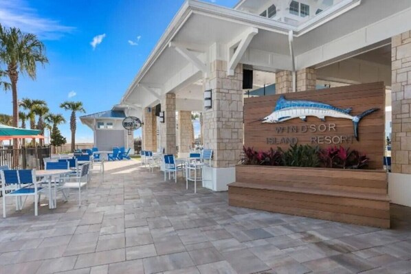 A resort with a sign reading "Windsor Island Resort," outdoor seating, and palm trees.