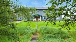 A house with a front porch, a pathway leading to the entrance, and a well-maintained lawn.