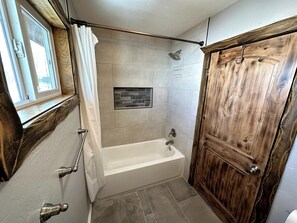 Een douche, handdoeken, zeep, toiletpapier
