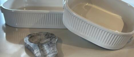 Two white ceramic dishes with ridged sides on a countertop.