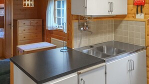 Eine Küche mit schwarzem Arbeitsplatz, Spüle aus Edelstahl und weißen Schränken.