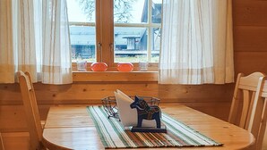 Ein Holztisch mit Untersetzer und einer dekorativen Pferdefigur. An jeder Seite des Tisches stehen zwei Stühle.