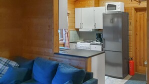 Eine kleine Küche mit Herd, Mikrowelle und Kühlschrank.