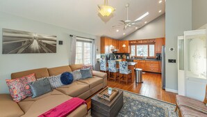 A spacious living room with a sofa, coffee table, and a view of the kitchen. - Lake Front Home w/Dock, Kayak, Canoe Right On Lake Hopatcong w/AC Wifi Huge Deck (Jefferson Township)