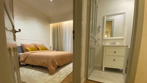 Un dormitorio con cama, mesita de noche y espejo.