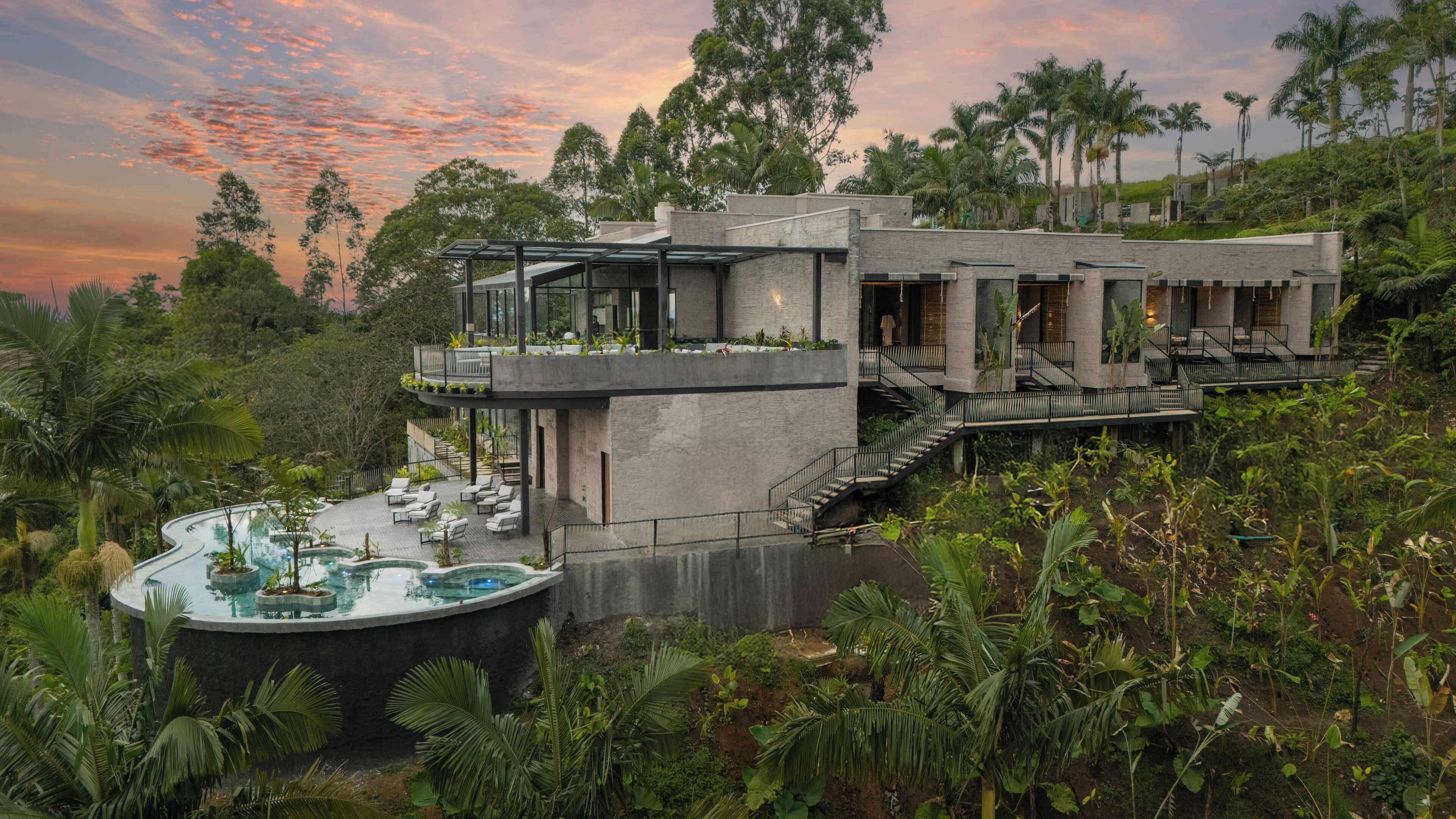 Une villa moderne dotée d’une piscine, d’un espace salon extérieur et d’une végétation luxuriante.