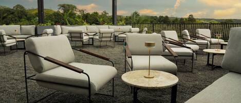 An outdoor seating area with modern furniture and a view of the landscape.