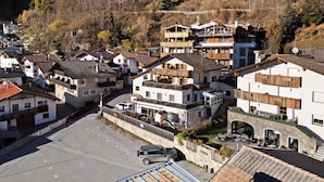 A cluster of traditional European-style buildings with balconies, a central paved area, and a mountainous backdrop. - Apartment "Haus Peer A 2" with Mountain View, Private Terrace, and Wi-Fi (Mals)