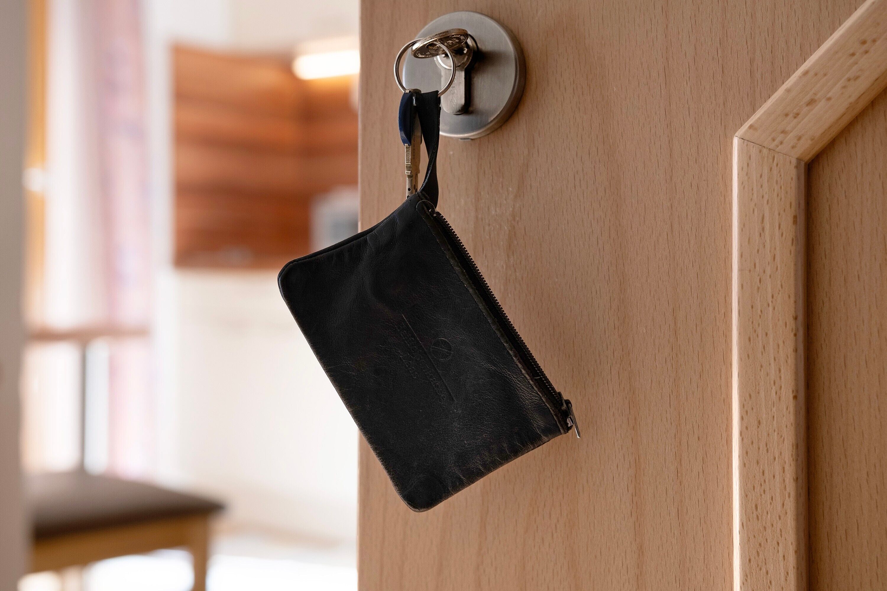 Un bolso de cuero negro colgado de una cerradura.