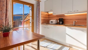 A kitchen with white cabinets, a wooden countertop, a microwave, and a coffee maker. - Apartment "Haus Peer A 2" with Mountain View, Private Terrace, and Wi-Fi (Mals)