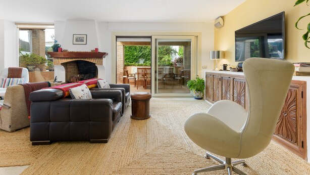 A living room with a sofa, armchair, fireplace, and a television. - Villa 'Rio Verde' with Sea View, Wi-Fi and Air Conditioning (Marbella)