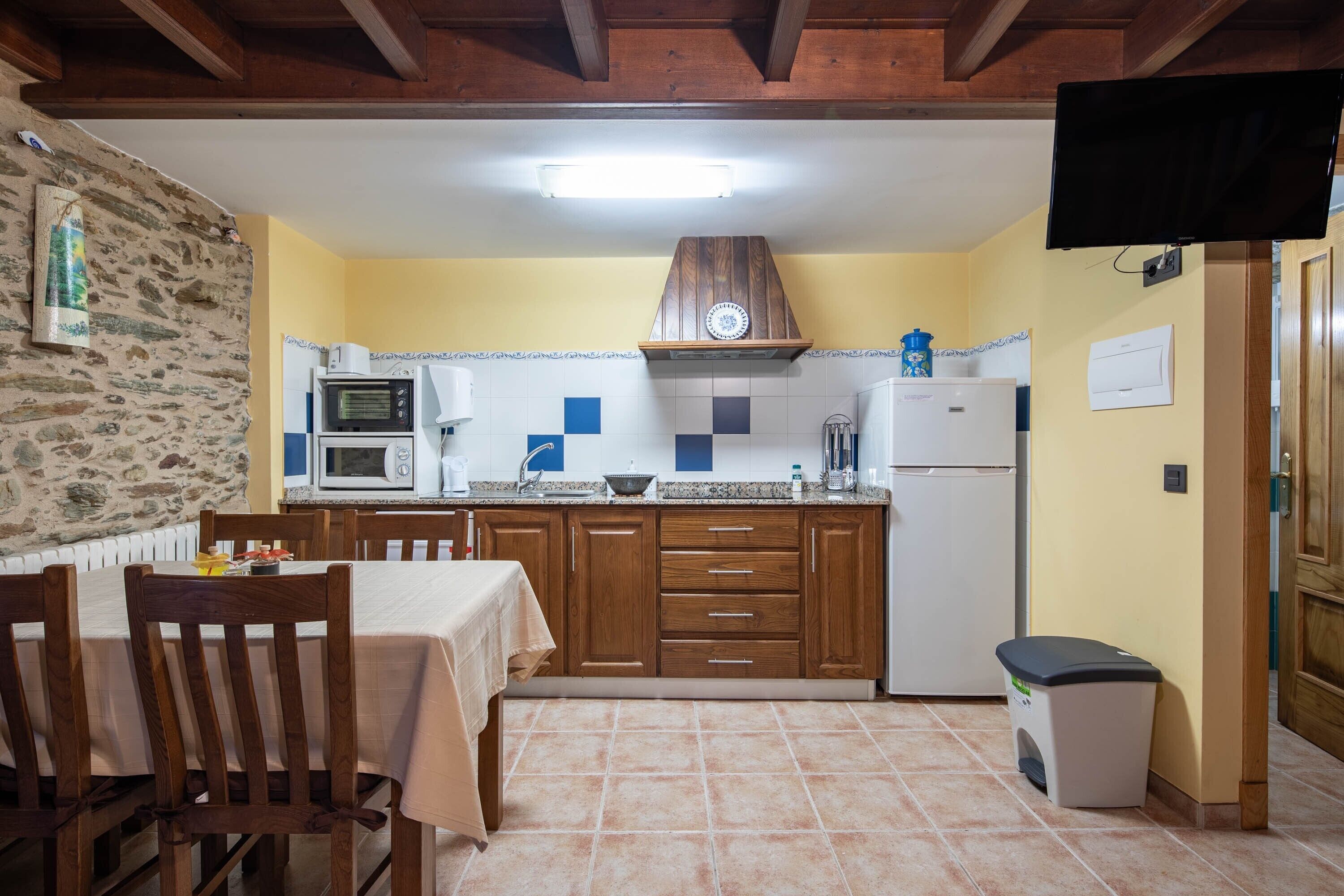A kitchen with wooden cabinets, a microwave, a stove, and a sink.