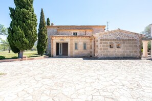 A stone building with a tiled roof, a central door, and a small window.
