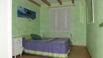 Ein Schlafzimmer mit einem Bett, einem Nachttisch und einem Bild an der Wand.