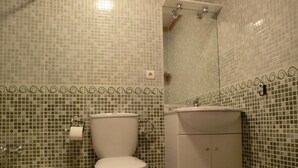 Un baño con inodoro, lavamanos y ducha.