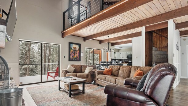 A spacious living room with a high ceiling, large windows, and a cozy seating area. - 'Enchanted Pines' Mountain Escape! (Angel Fire)