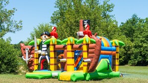 Una estructura inflable para jugar con varias figuras de animales y una bandera de pirata.