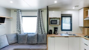 A compact kitchenette with a microwave, coffee maker, and sink.