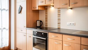 Eine moderne Küche mit Holzausstattung, einem Backofen und einer Arbeitsplatte.