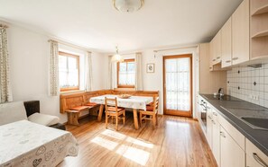 A cozy kitchen with wooden cabinets, a dining table, and a bench.
