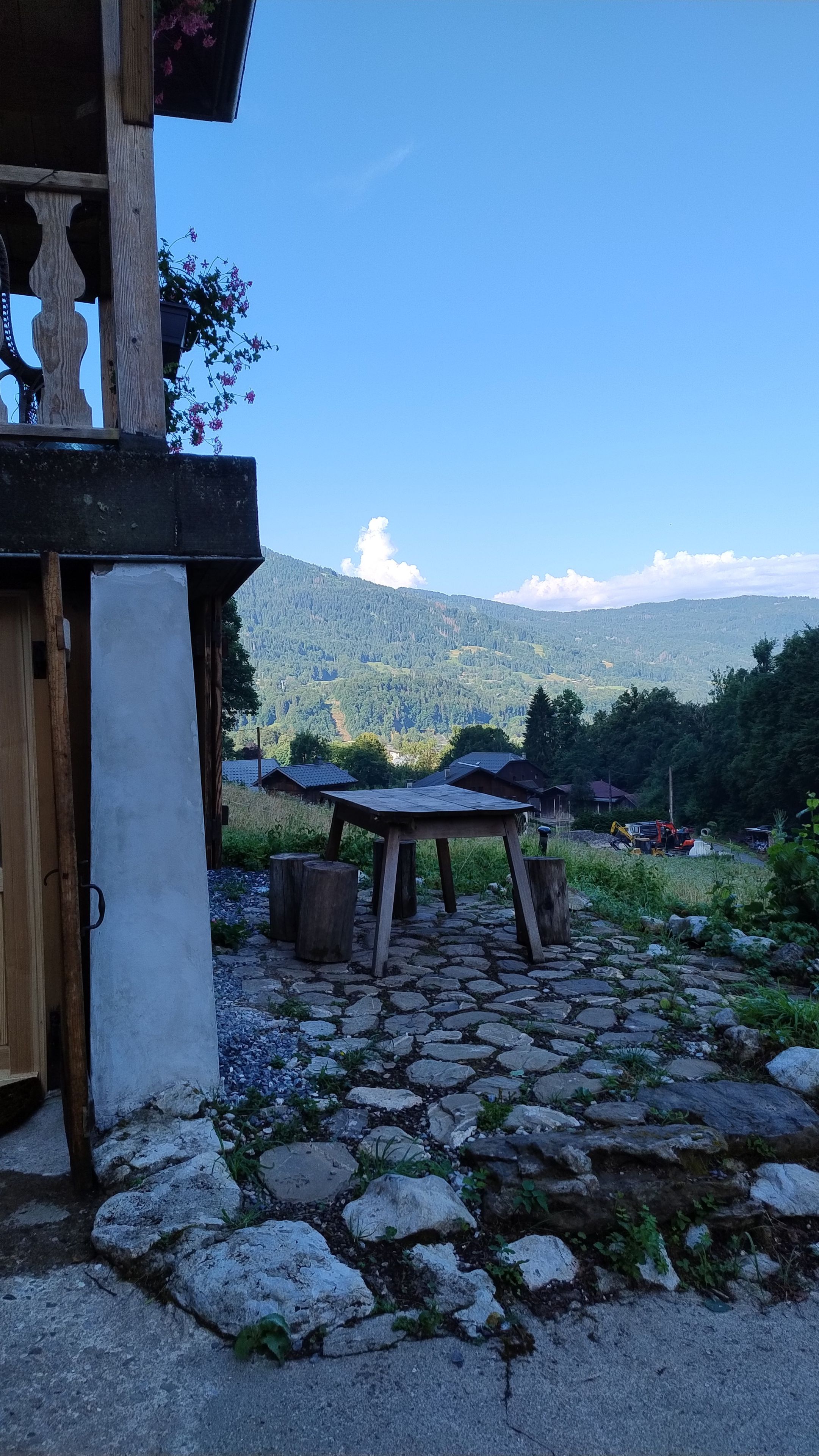 Un sendero de piedra que lleva a una estructura de madera con vistas a un paisaje montañoso.