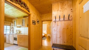 Un interior de madera con cocina, comedor y pasillo que conduce a un dormitorio.