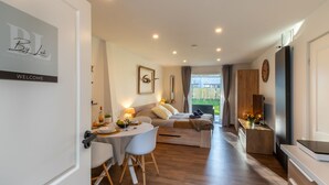 A modern living room with a dining area, a sofa, a coffee table, and a TV.