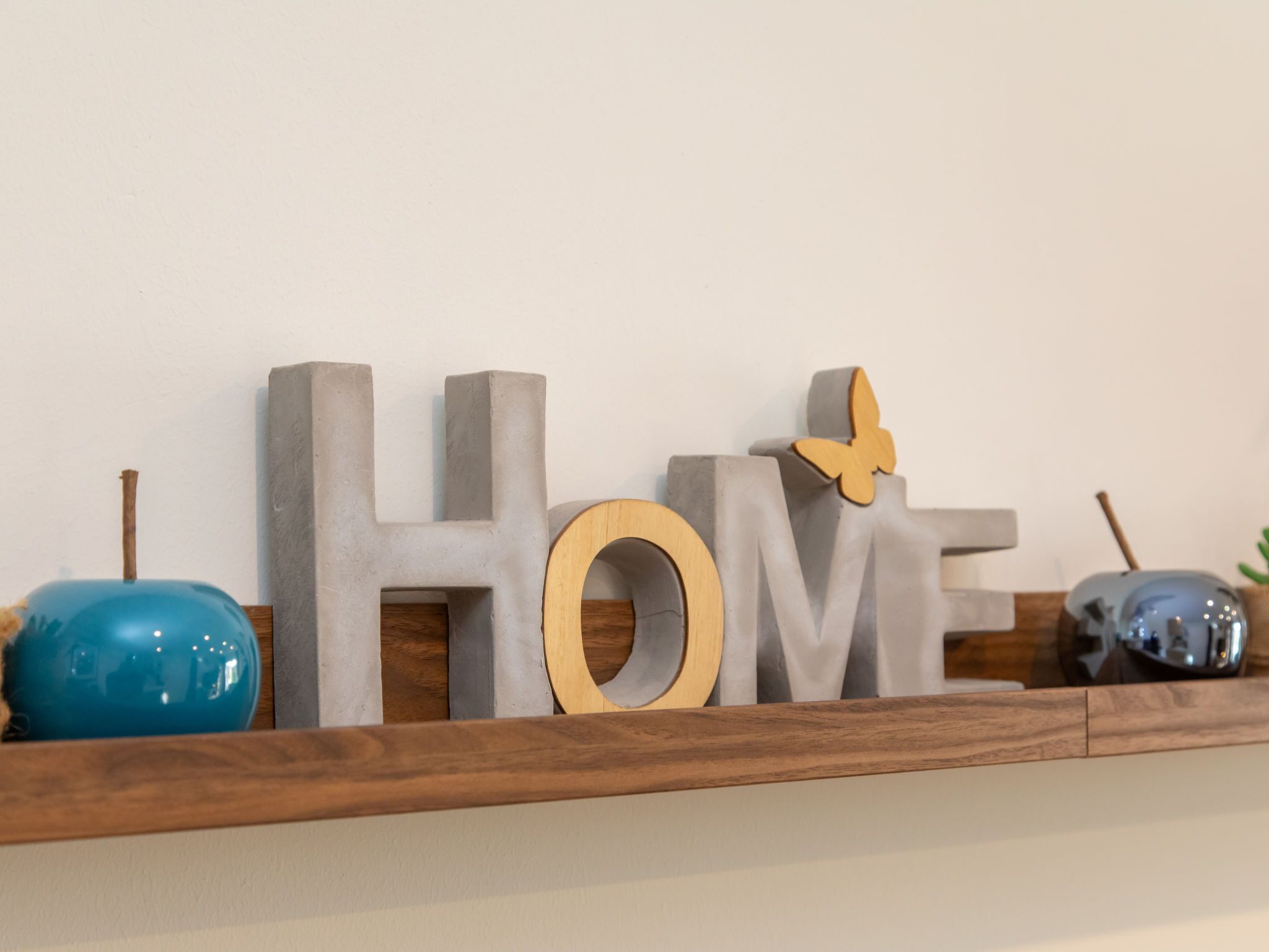 A shelf with decorative letters spelling "HOME" and a butterfly ornament.