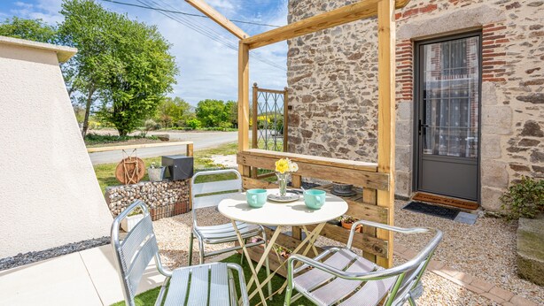 A covered outdoor seating area with a stone building, a door, and a window. - Holiday Home 'L'étable 15kms Puy Du Fou' with Private Terrace and Wi-Fi (Pouzauges)