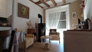A cozy living room with a fireplace, a dining area with a table and chairs, and a window with curtains.