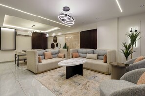 Uma sala de estar moderna com um sofá modular, uma mesa de centro redonda e um design de teto minimalista.