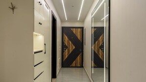 A hallway with a bench, a mirror, and a door with a geometric pattern. - Zahir - 701 (Giza Governorate)