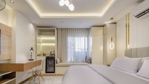 Ein modernes Hotelzimmer mit Bett, Schreibtisch und Sitzecke.