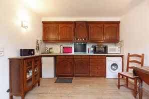 Een oven, een kookplaat, een waterkoker, kookgerei, borden en bestek