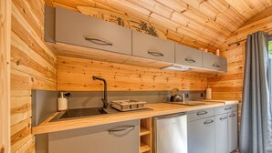 A compact kitchen with wooden walls, a stainless steel sink, and grey cabinets. - Ôtonneauxstress – Beach Attendant: Unique Experience Just Steps from the Atlantic (Saint-Vivien-de-Médoc)