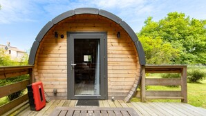 A wooden cabin with a door, a bench, and a red cooler on the deck. - Ôtonneauxstress – Beach Attendant: Unique Experience Just Steps from the Atlantic (Saint-Vivien-de-Médoc)