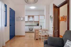 Moderni keittiö, jossa on valkoiset kaapit, puinen työtaso ja sisäänrakennettu uuni.