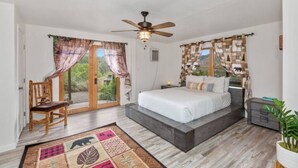 A bedroom with a bed, a chair, a bedside table, a ceiling fan, and a view through the glass door. - No Cleaning Fee ~ Awesome Views~8Beds~Near Restaurants & Sequoia Park (Three Rivers)