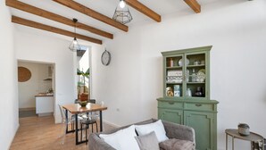 A living room with a sofa, a dining table with chairs, a green cabinet, and a clock on the wall. - 'Marcela Joaquin  Mountain House' with Sea View, Private Pool and Wi-Fi (Fasnia)