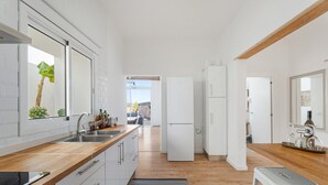 A modern kitchen with a wooden countertop, white cabinets, a refrigerator, and a view to the outside. - 'Marcela Joaquin  Mountain House' with Sea View, Private Pool and Wi-Fi (Fasnia)