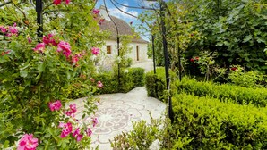 A garden with a pathway leading to a white building with a tiled roof. - Chez Jacquou – Authentic Charm and Modern Comfort with Private Pool in the Heart of Périgord (Bouniagues)