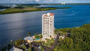 Un hôtel de grande hauteur offrant une vue sur une étendue d’eau et la végétation environnante.