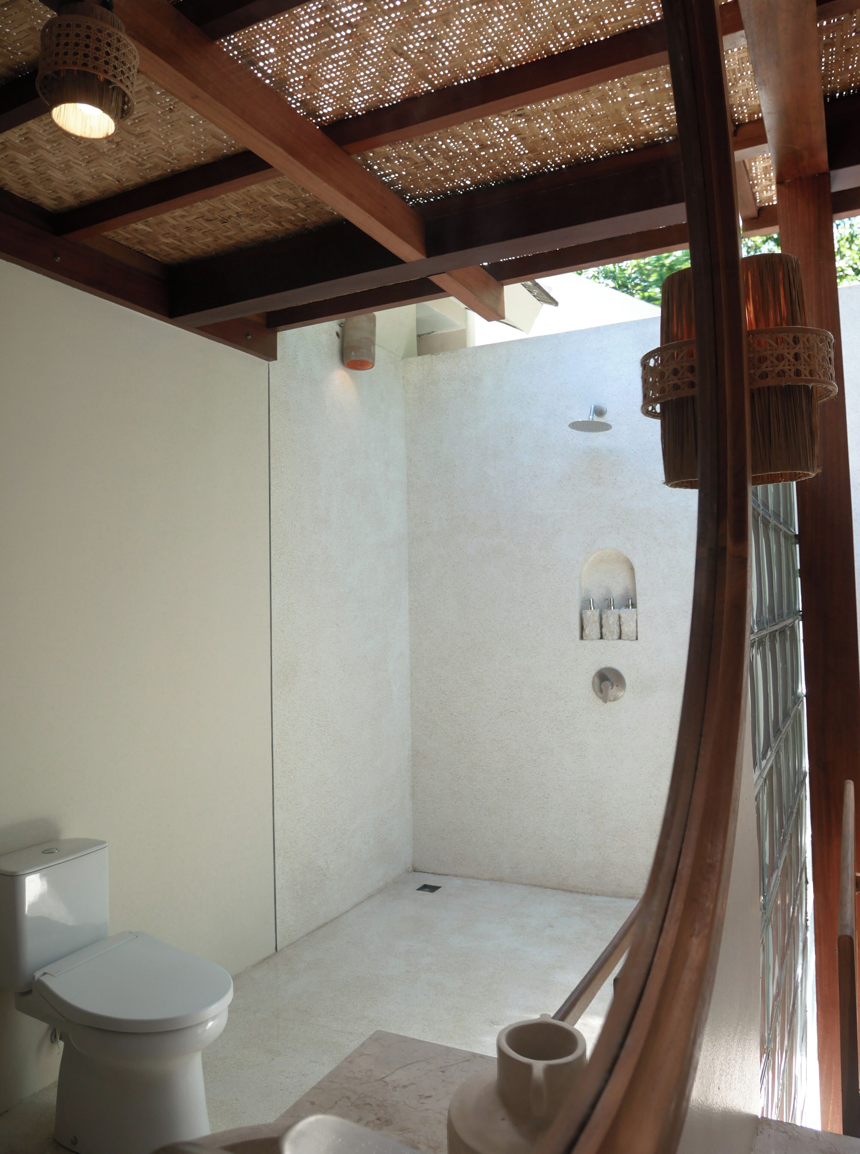 A modern bathroom with a shower, toilet, and a small sink.