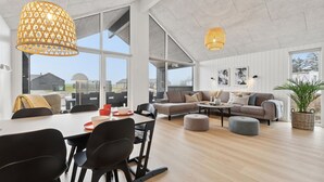 Amplia sala de estar con un gran comedor, asientos cómodos y ventanas amplias con vistas al exterior.
